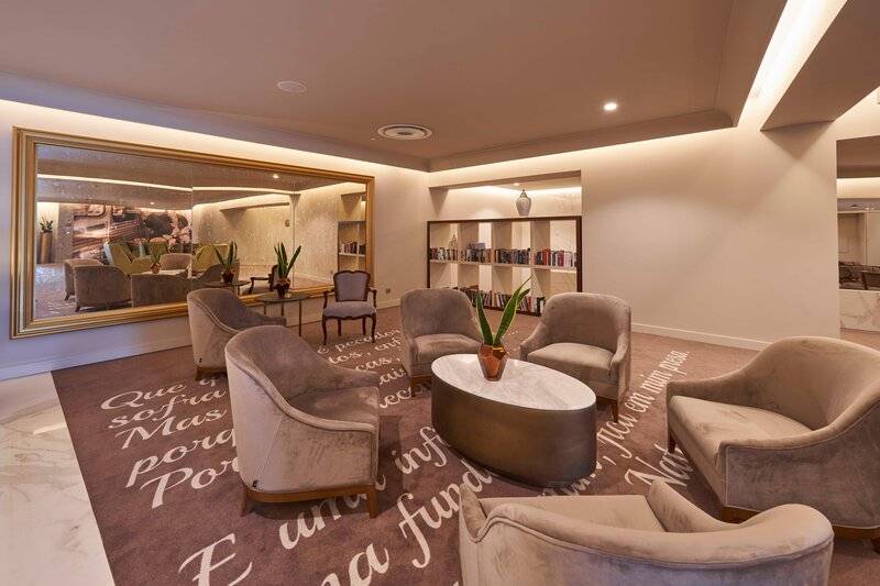 Lobby des Savoy Palace Hotels mit Teppich, Sofas und einem großen Spiegel.