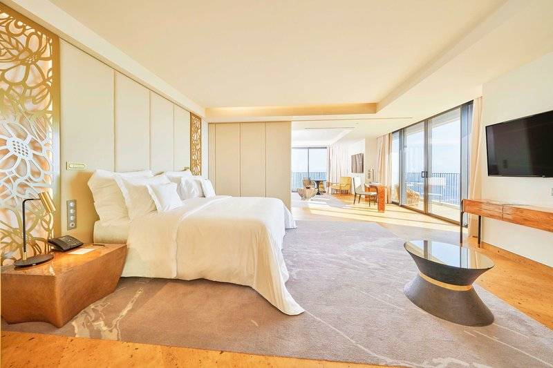 Luxuriöses Schlafzimmer im Savoy Palace Hotel mit großem Bett, Panoramafenstern und moderner Einrichtung.