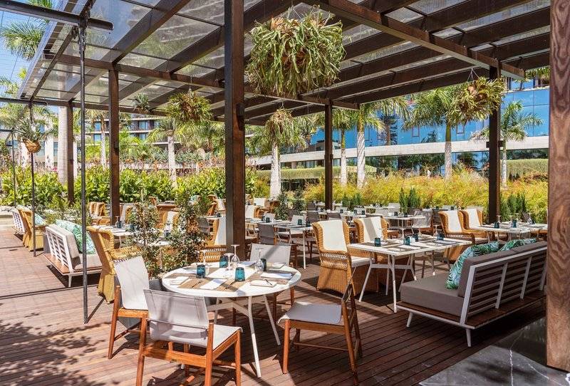 Gartenrestaurant im Savoy Palace Hotel mit Tischen und Stühlen unter einem Dach