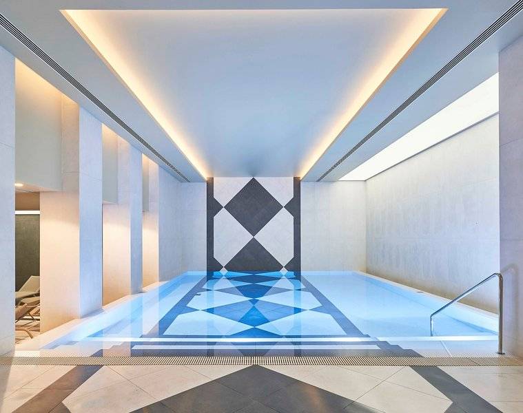 Innenpool des Savoy Palace Hotels mit blauen Wasser und geometrischem Bodendesign.