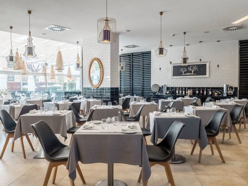 Restaurant des Aqua Pedra dos Bicos Hotels mit gedeckten Tischen und Stühlen.