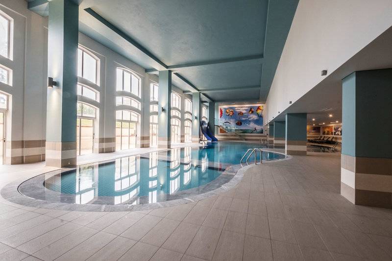 Innenpool im Vila Galé Cerro Alagoa Hotel mit blauen Wänden und einer Rutsche.