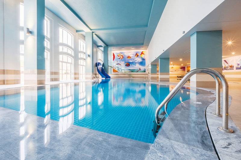 Innenpool des Vila Galé Cerro Alagoa Hotels mit blauer Rutsche und marmorierter Umgebung