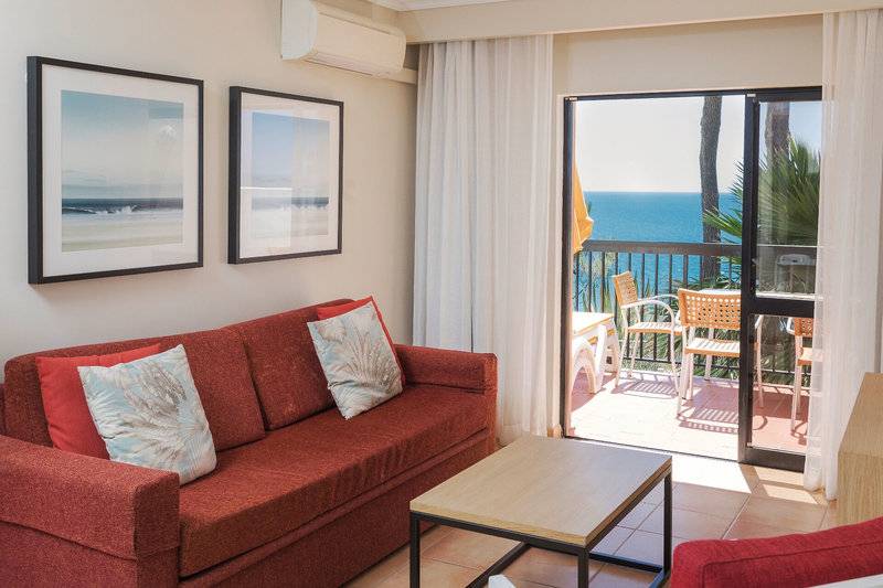 Wohnzimmer im Alfagar Village Hotel mit Blick auf das Meer und Balkon.