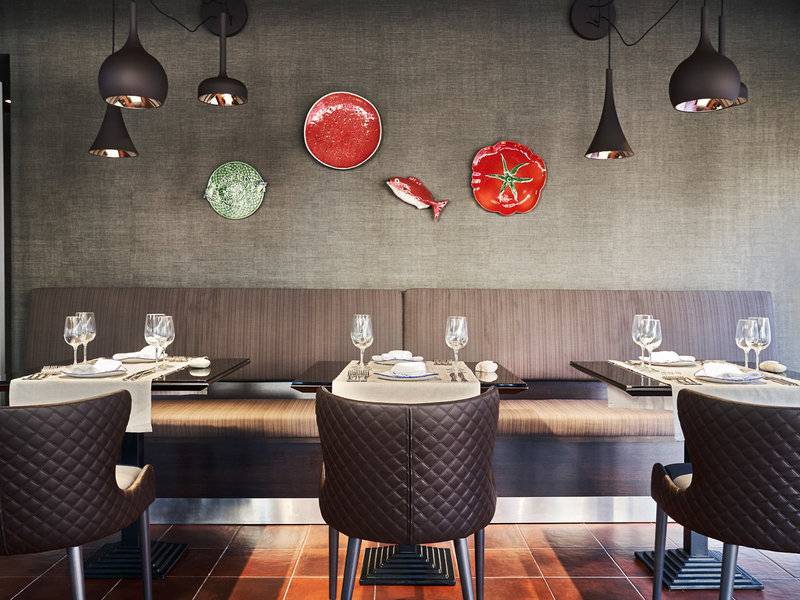 Innenansicht des Restaurants im Falesia Hotel in Algarve mit Tisch, Stühlen und dekorativen Wandelementen.