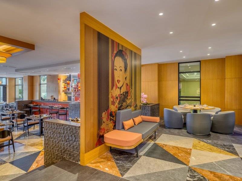Innenbereich des Rixos Premium Belek Hotels mit moderner Einrichtung, gemustertem Boden und einer großen Wandkunst.