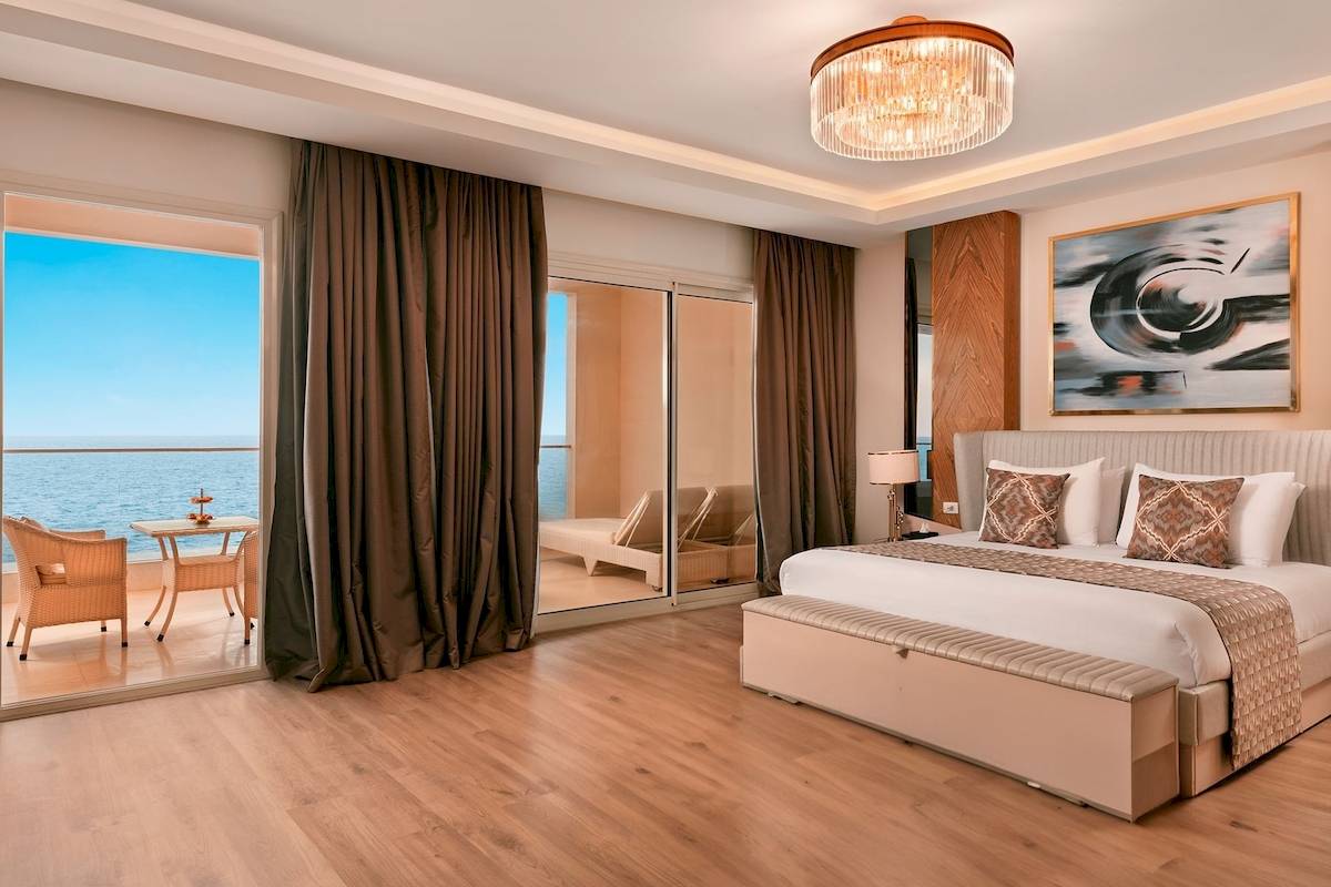 Luxuriöses Zimmer im Pickalbatros Citadel Resort mit Meerblick und Terrassenmöbeln.