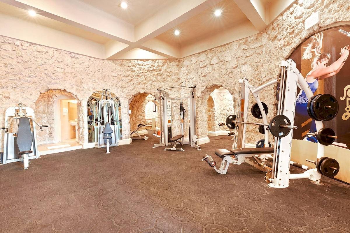 Fitnessraum im Pickalbatros Citadel Resort mit Steinwänden und verschiedenen Trainingsgeräten.