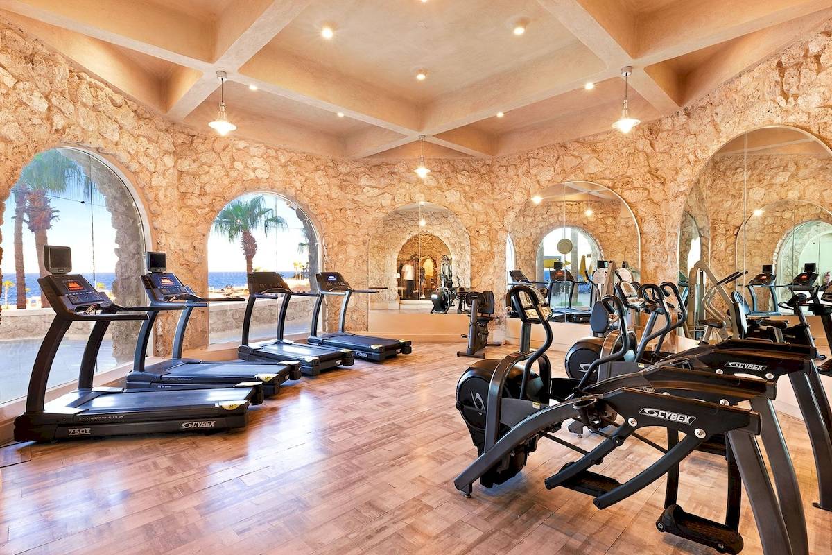 Fitnesscenter im Pickalbatros Citadel Resort mit Steinwänden und modernen Trainingsgeräten.
