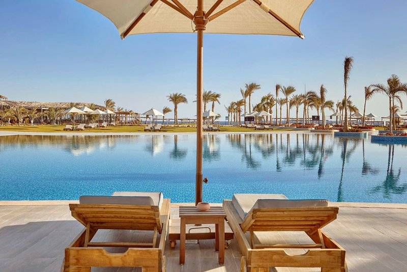 Pool-Lounge-Bereich im Steigenberger Resort Alaya mit zwei Holzliegen und einem Schirm