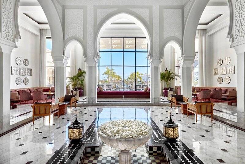 Lobby des Steigenberger Resort Alaya mit weißen Wänden, Marmorboden und großen Glasfenstern.