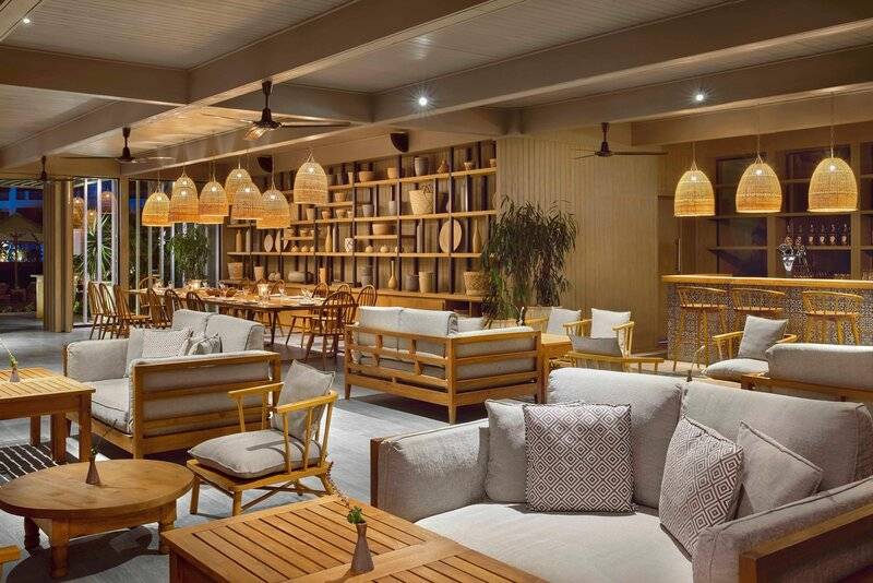 Innenbereich der Lounge im Steigenberger Resort Alaya mit Holzmöbeln, Deckenventilatoren und Regalen.