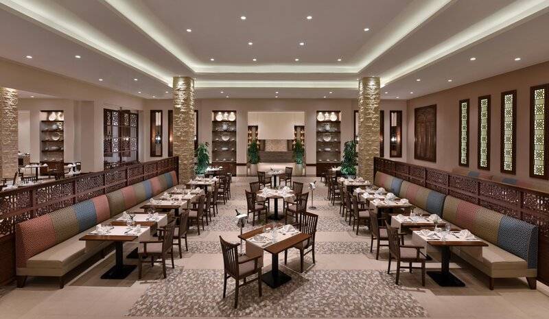 Innenansicht des Restaurants im Steigenberger Resort Alaya mit bunten Sitzbänken und Tischen.