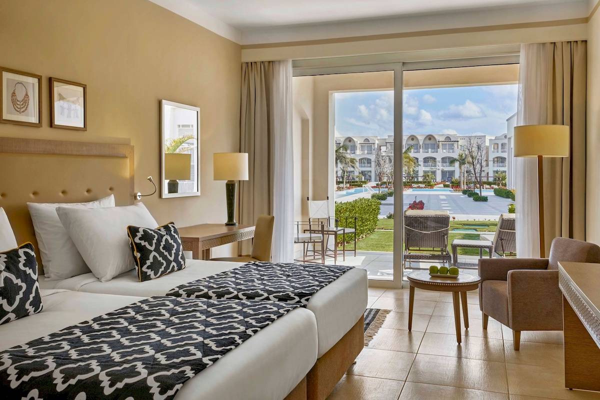 Doppelzimmer im Steigenberger Resort Alaya mit zwei Betten und Ausblick auf den Pool.