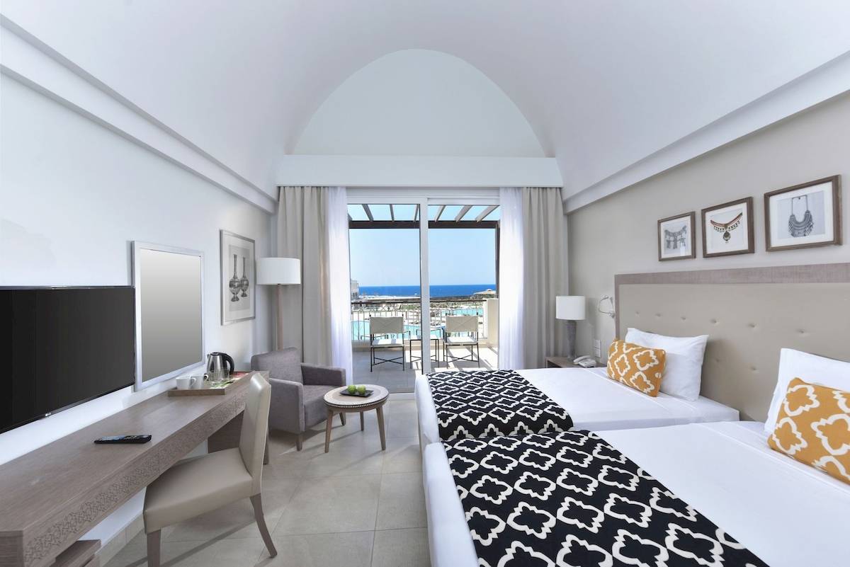 Zimmer im Steigenberger Resort Alaya mit zwei Betten, Schreibtisch und Aussicht auf den Ozean.