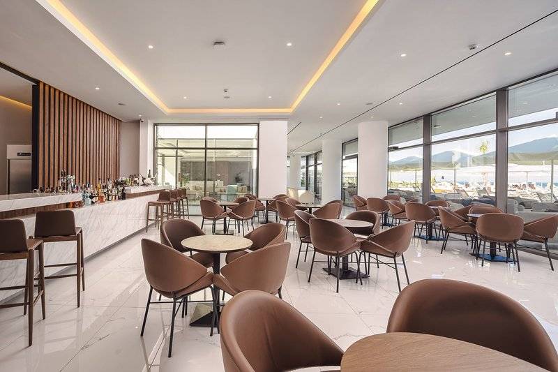 Innenbereich der Lounge im Lindos Grand Resort & Spa mit vielen Sitzgelegenheiten und einer Bar.