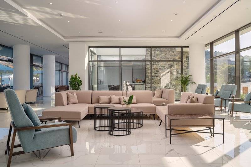 Lobbybereich im Lindos Grand Resort & Spa mit großen Sofas und modernen Möbeln.