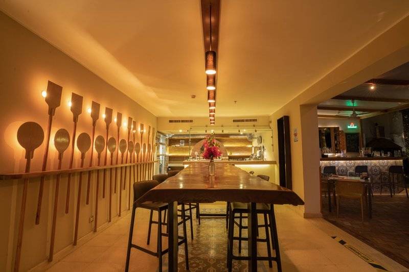 Innenansicht des Restaurants des Fort Arabesque Resort, Spa & Villas mit langen Holztischen und Stühlen.