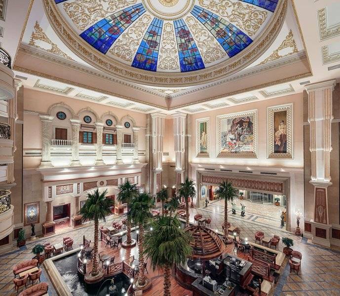 Innenansicht der Lobby des Palm Royale Soma Bay Hotels mit hoher Decke und bunten Glasmalereien.