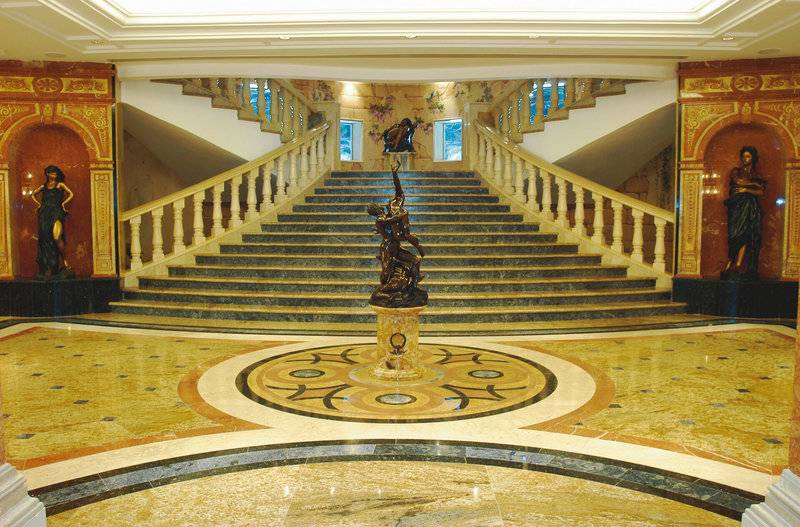 Lobby des Palm Royale Soma Bay Hotels mit einem zentralen Brunnen und zwei Statuen an den Seiten.
