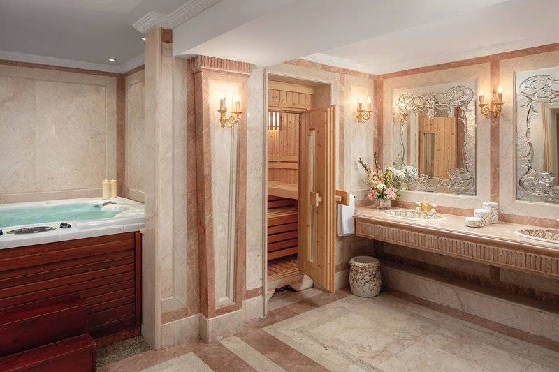 Badezimmer im Palm Royale Soma Bay Hotel mit Whirlpool, Sauna und zwei Waschbecken.