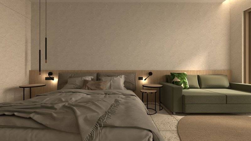 Modernes Schlafzimmerdesign im Alexandra Beach Resort mit Bett, Couch, Nachttischen und Teppich.