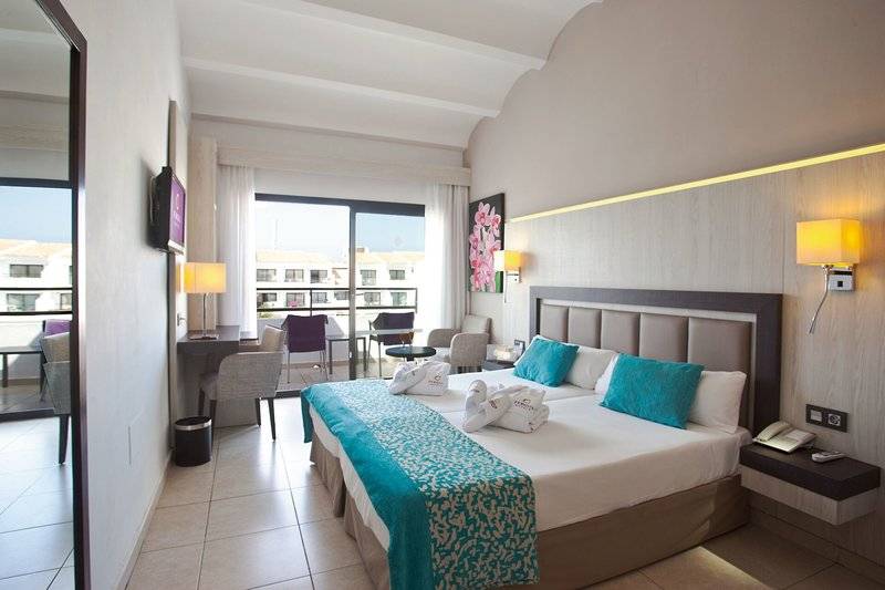 Doppelzimmer im Fergus Style Bahamas Hotel mit Balkon, zwei Betten und modernen Möbeln.