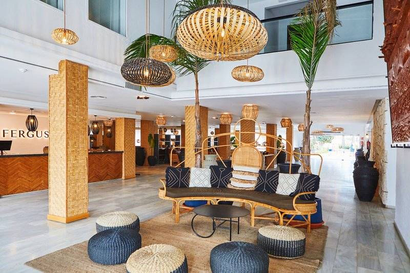 Lobby des Fergus Style Bahamas Hotels mit modernen Möbeln, Palmen und dekorativen Lampen.