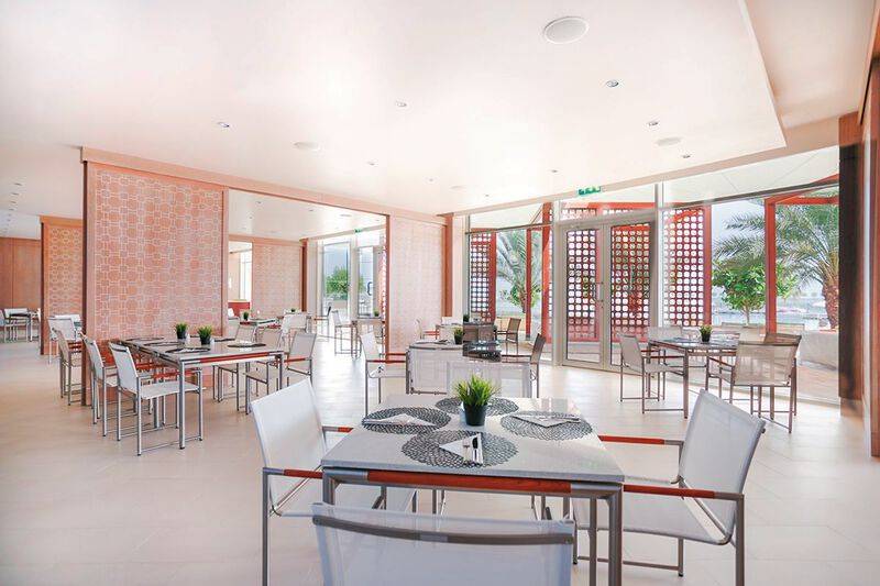 Innenbereich des Restaurants im Barcelo Mussanah Resort mit modernen Möbeln und Panoramafenstern.