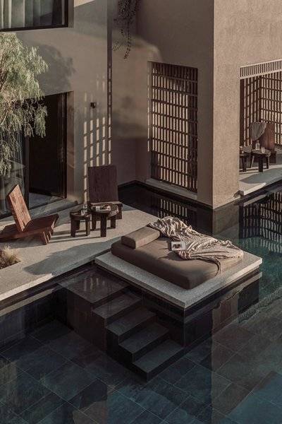 Poolside-Lounge-Bereich im Casa Cook Samos Hotel mit betten, holzstuhle und tisch.