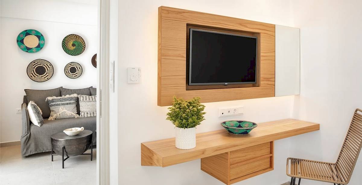 Hotelzimmer im Kalidon Panorama mit Wohnzimmer, Fernseher, Dekopflanzen und Korb.