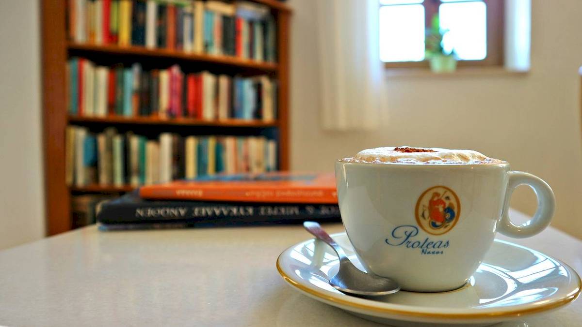 Eine Tasse Kaffee mit Sahne auf einem Teller im Proteas Hotel & Suites.