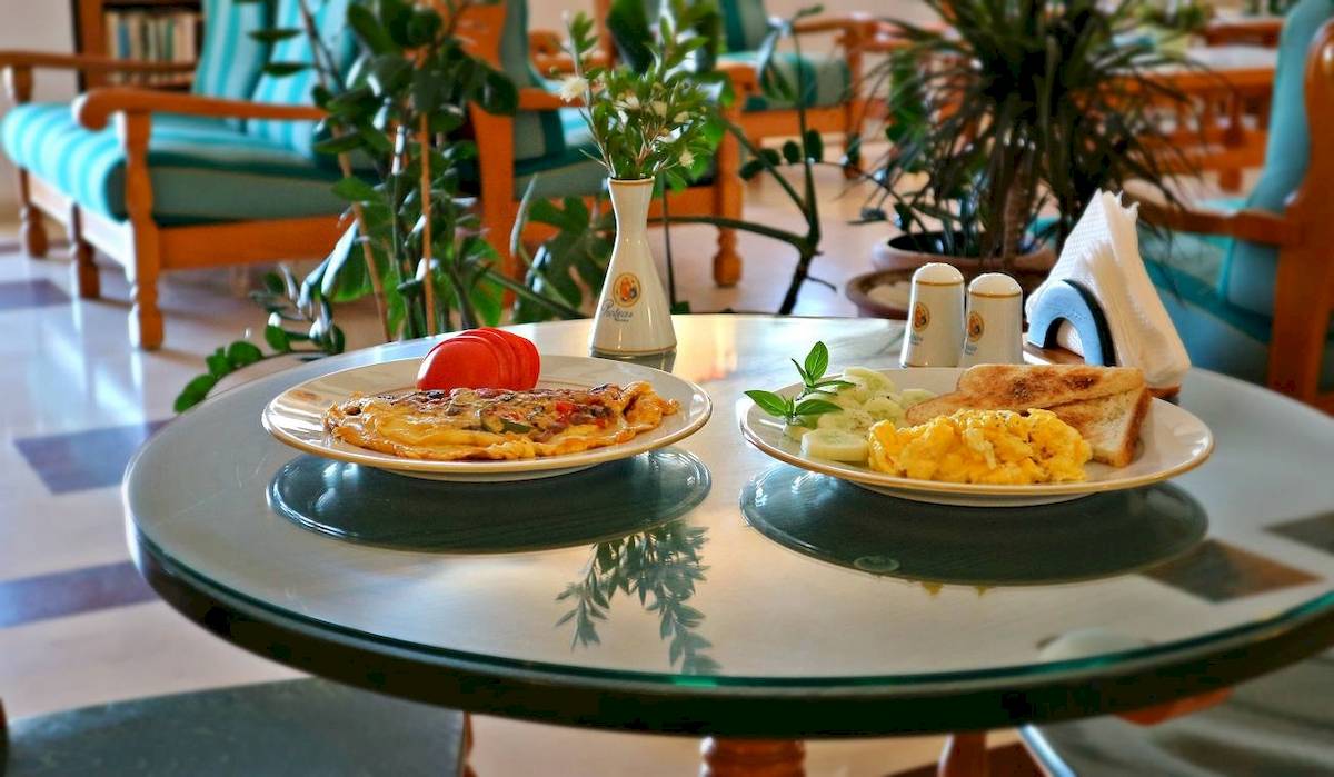 Frühstückstisch im Proteas Hotel mit Rührei, Gemüse und Toast.