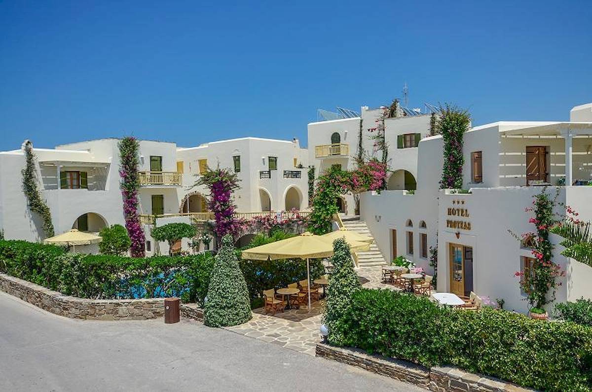 Außenansicht des Proteas Hotel & Suites mit Swimmingpool und Terrassenmöbeln.