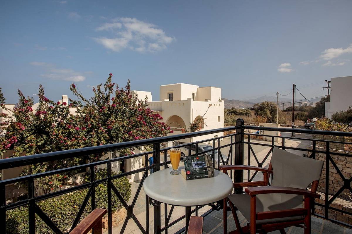 Blick vom Balkon des Proteas Hotel & Suites mit einem Tisch, zwei Stühlen und einem Buch.