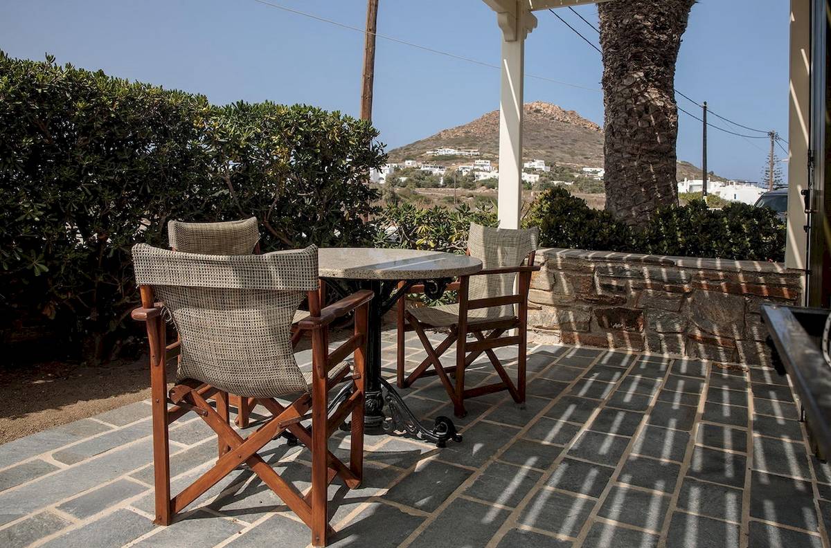 Terrasse des Proteas Hotel & Suites mit Tischen und Stühlen.