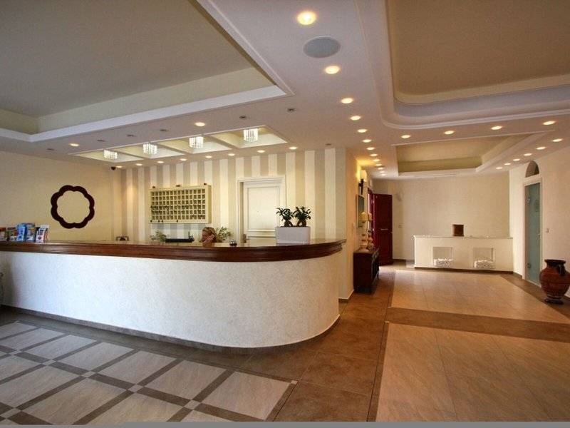 Empfangsbereich des Aegean Palace Hotels mit Rezeptionstresen, Pflanzen und moderner Inneneinrichtung.