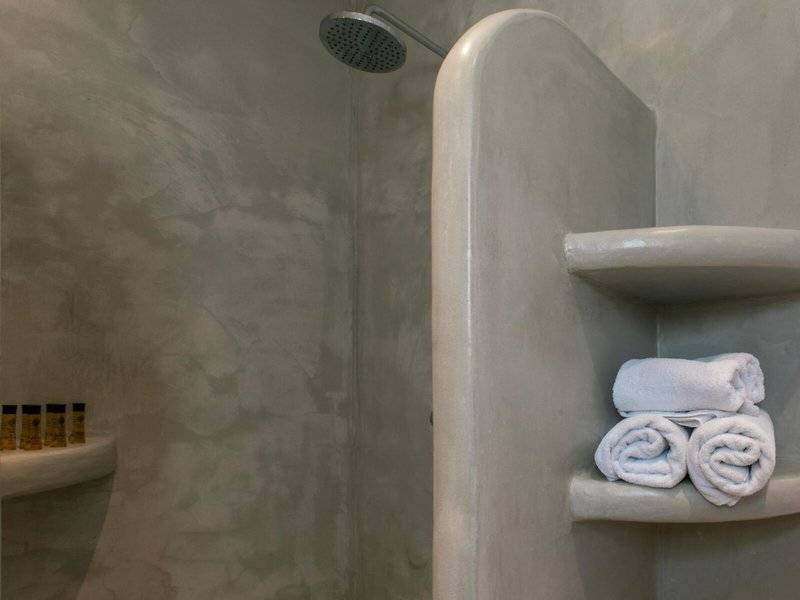 Dusche im Mikri Vigla Hotel mit weißen Handtüchern und Hygieneprodukten.