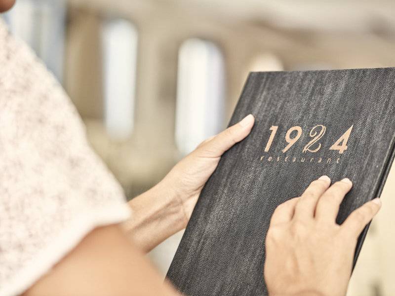 Frau hält ein Buch des 1924 Restaurants in den Händen.