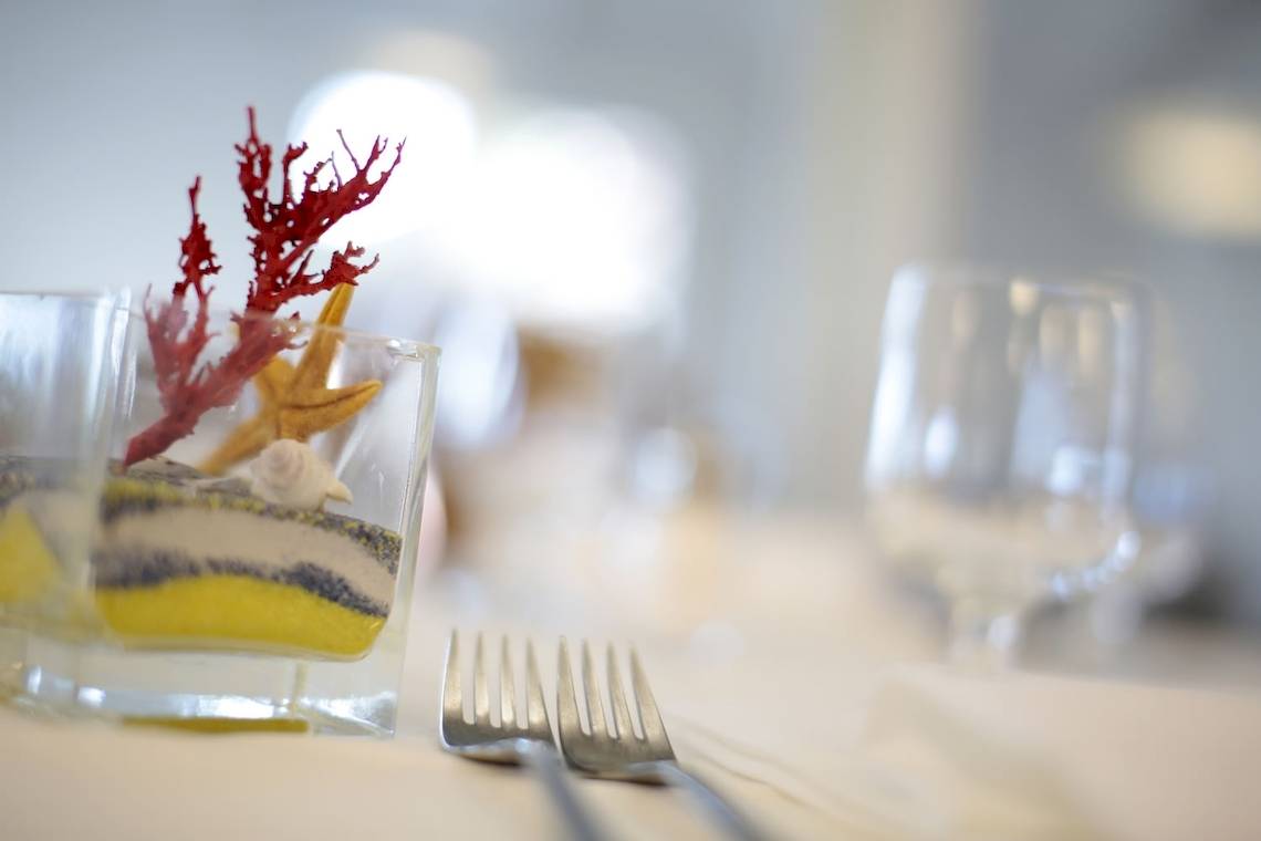 Tischdekoration im Mare Pineta Hotel mit Meereselementen in einem Glas.