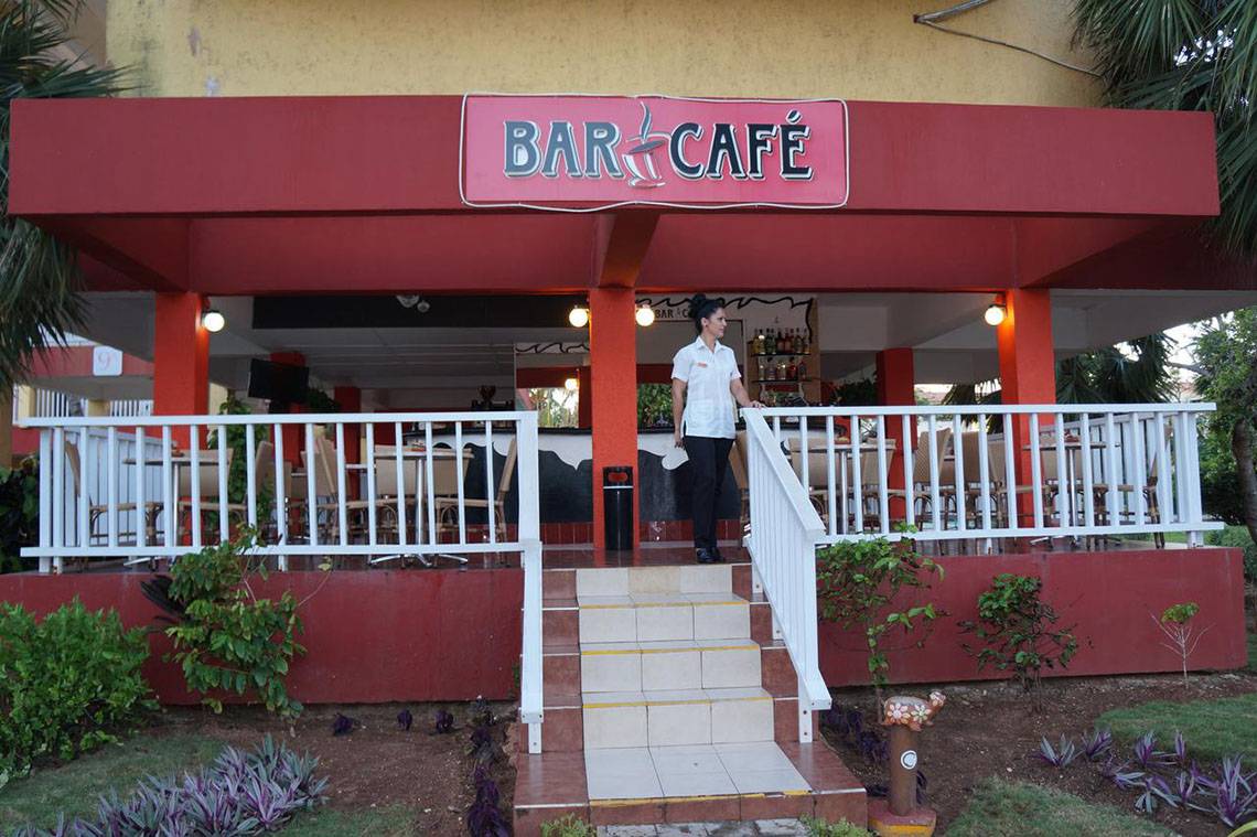Eingang zum Bar Cafe mit einer Frau in Uniform, die auf die Treppe schaut.
