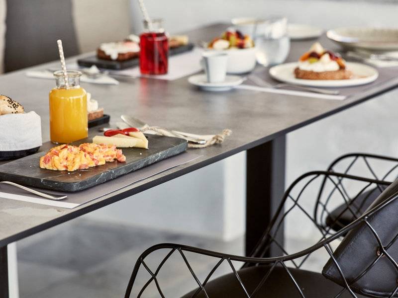 Frühstückstisch im Poseidon of Paros Hotel & Spa mit verschiedenen Speisen und Getränken.