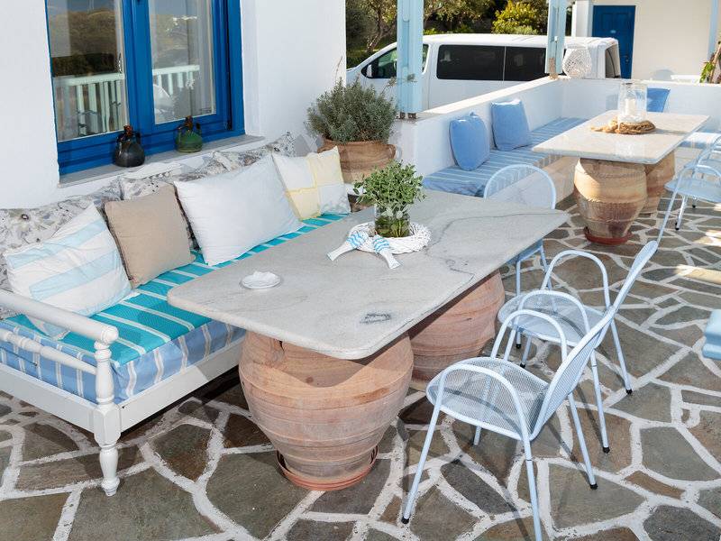 Die Terrasse des Pyrgaki Hotels mit Möbeln, Kissen und Pflanzen.