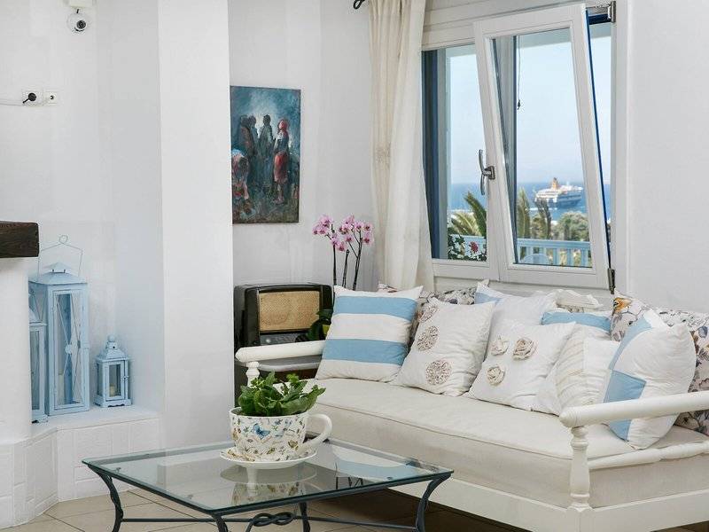 Wohnzimmer des Pyrgaki Hotels mit Blick auf das Meer und eine offene Terrasse.