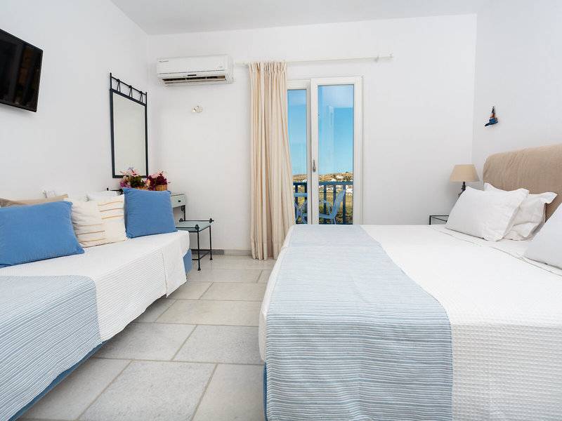Schlafzimmer im Pyrgaki Hotel mit Balkon, zwei Betten, Klimaanlage und Fernseher.