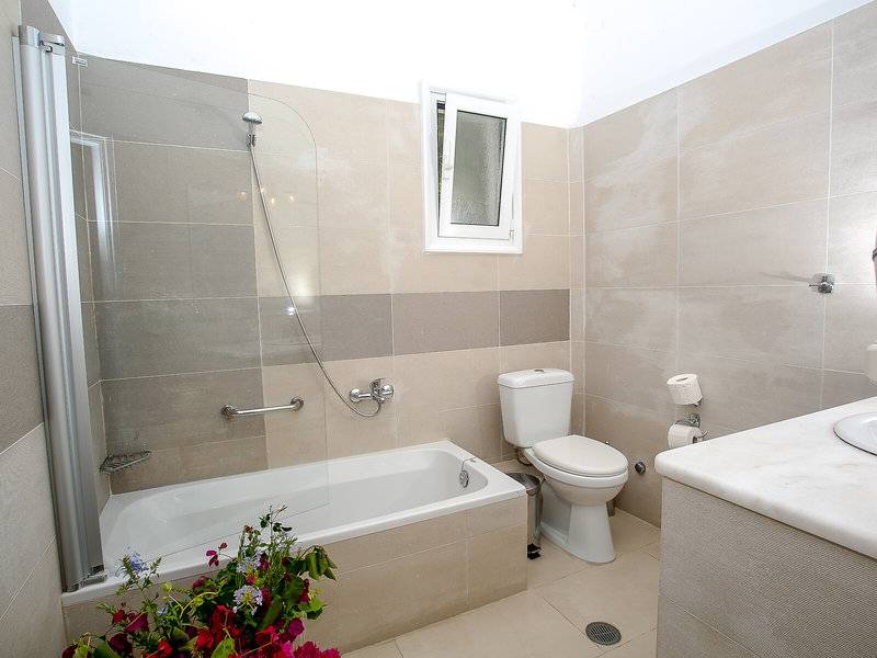 Ein Badezimmer mit einer Badewanne, Dusche, Toilette und Waschbecken.