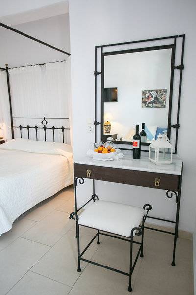 Schlafzimmer mit Bett, Kommode und Spiegel im Pyrgaki Hotel.