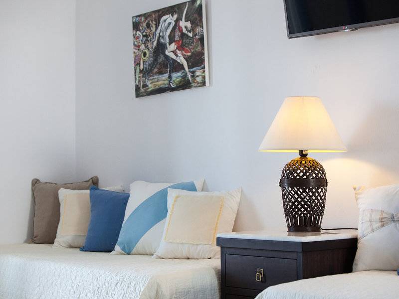 Schlafzimmer im Pyrgaki Hotel mit Lampen und Fernseher an der Wand.