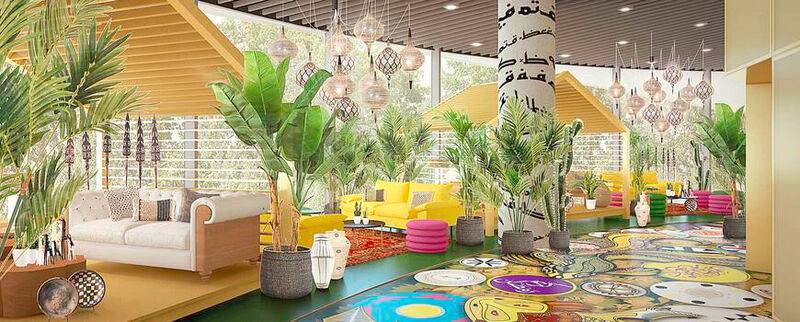 Innenraum des nhow Amsterdam RAI mit gelben Sofas, bunten Teppichen und vielen Pflanzen.
