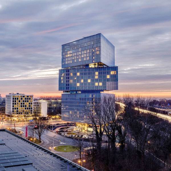 Luftaufnahme des nhow Amsterdam RAI Gebäudes bei Sonnenuntergang.